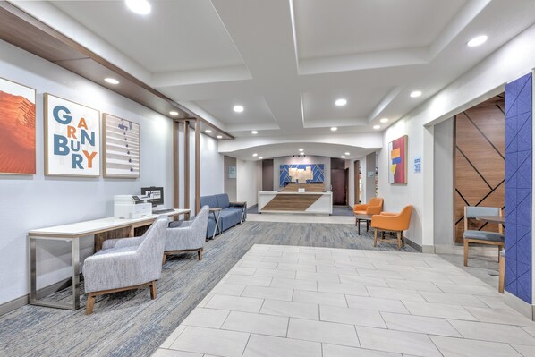 A modern lobby with a reception desk, seating area, and artwork on the walls. - Holiday Inn Express & Suites Granbury by IHG (Granbury)