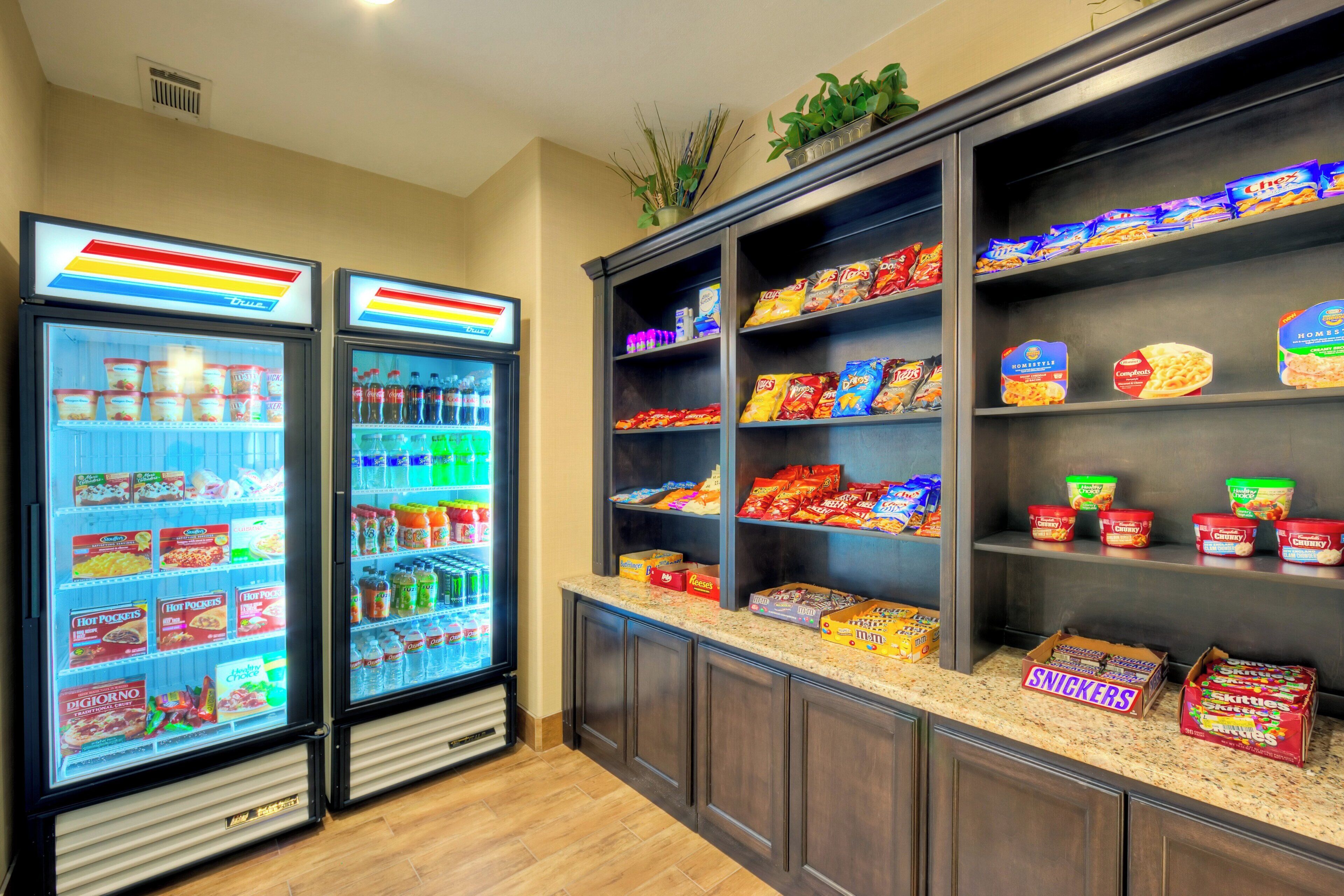 A snack bar with refrigerated drinks and a variety of packaged snacks.