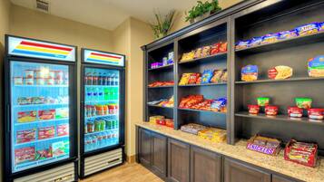 A snack bar with refrigerated drinks and a variety of packaged snacks.