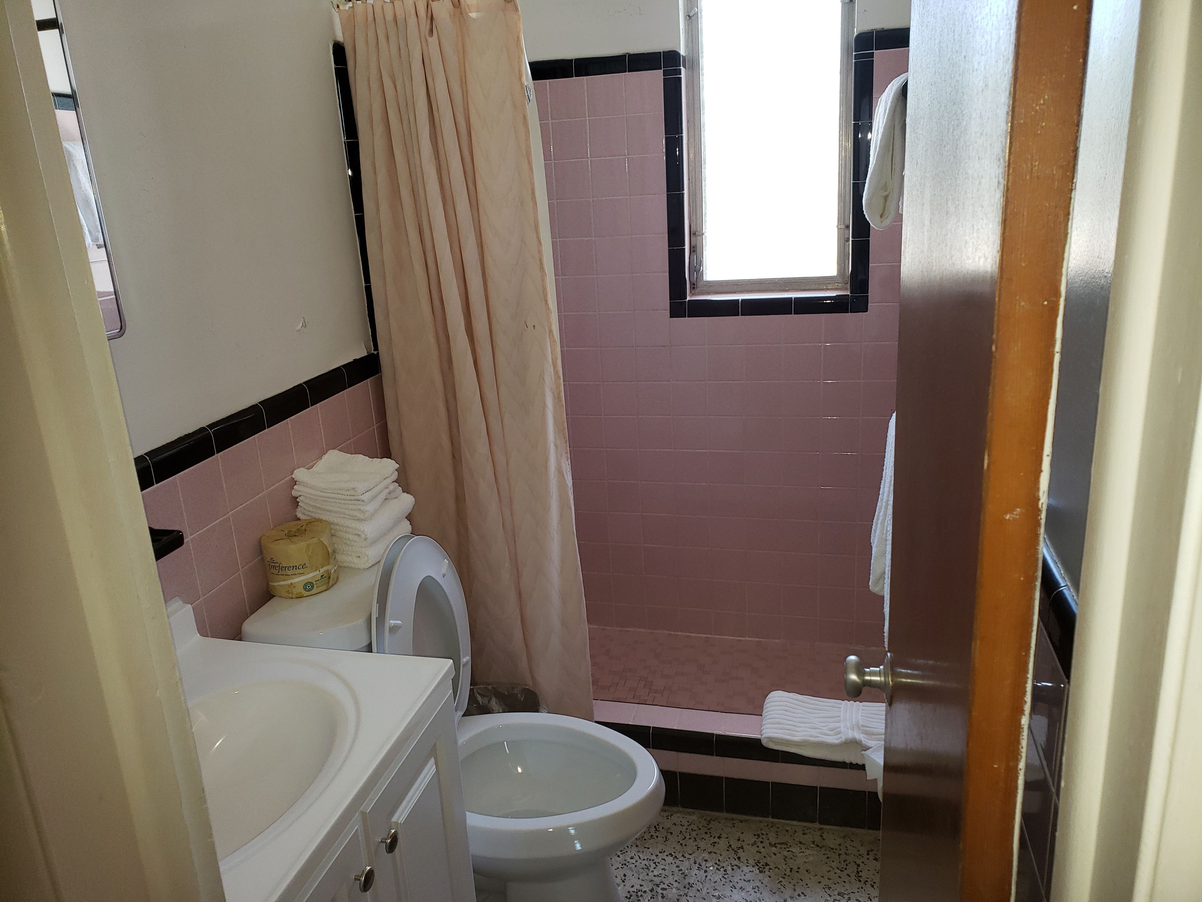 Un baño con inodoro, lavamanos y zona de ducha.
