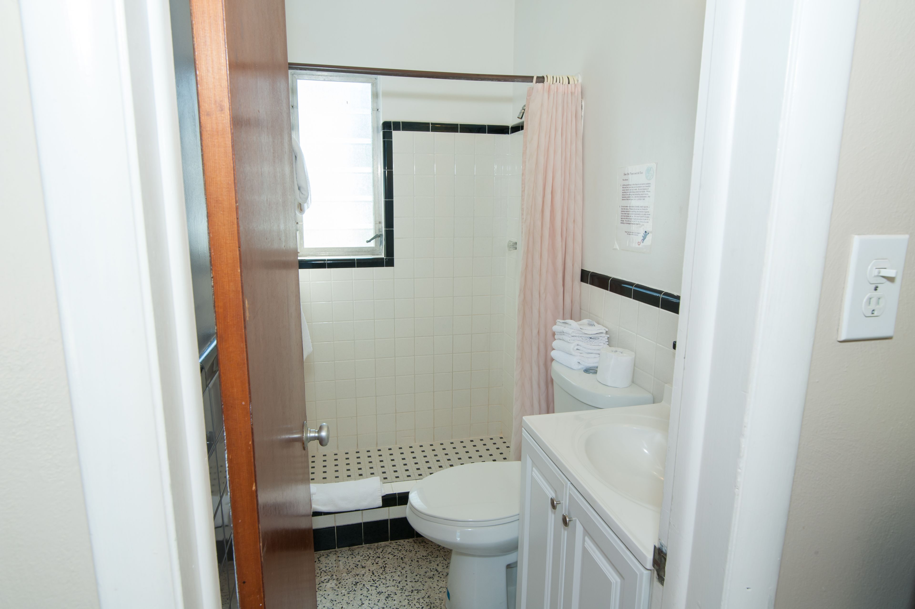 A small bathroom with a toilet, sink, and shower.