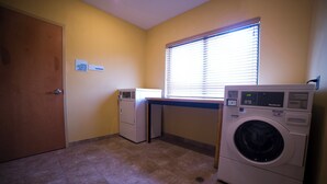 A laundry room with a washing machine, dryer, and a microwave.