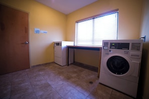 A laundry room with a washing machine, dryer, and a microwave. - Holiday Inn Express & Suites Atlanta East – Lithonia by IHG (Lithonia)