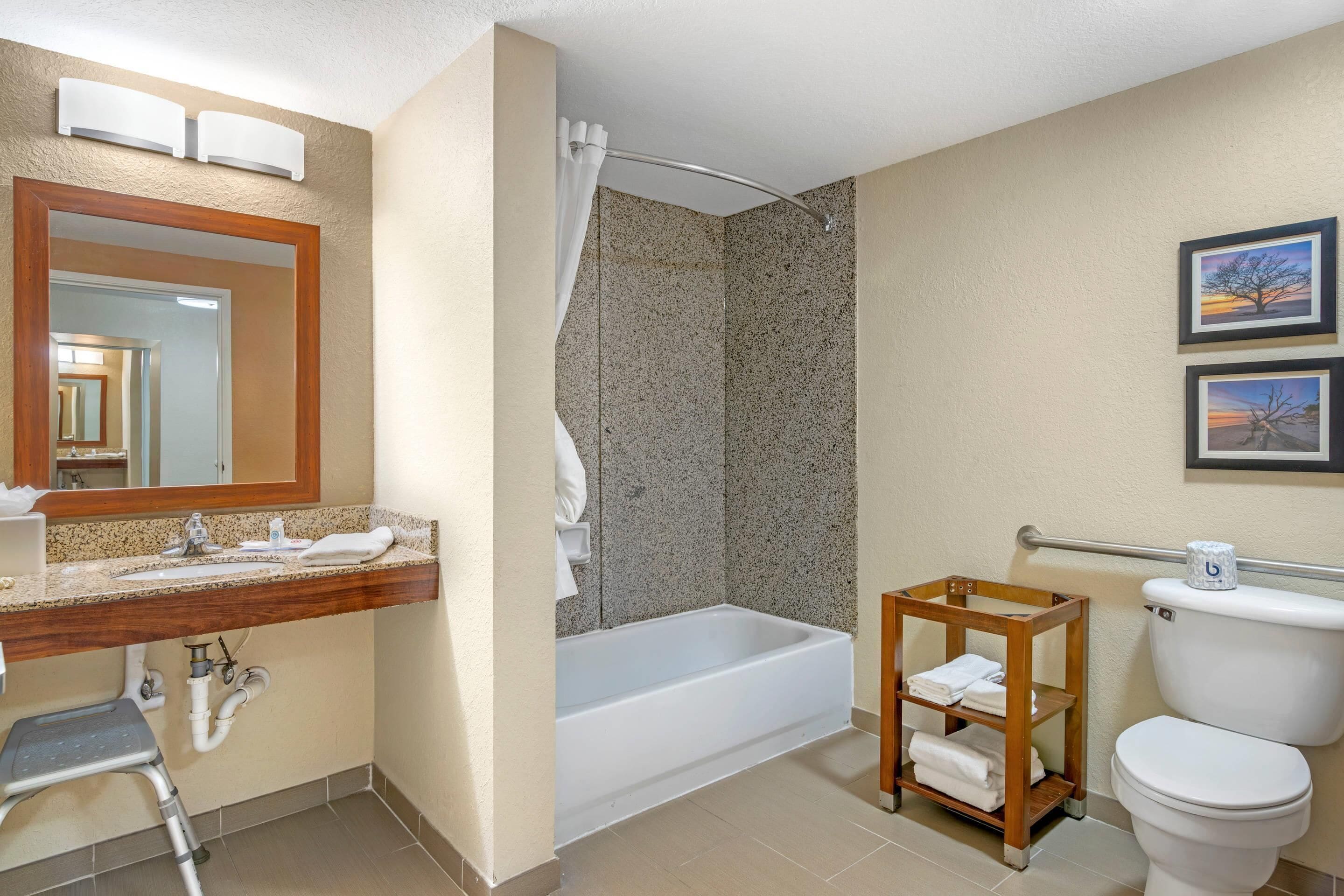A bathroom with a sink, mirror, shower, and toilet.