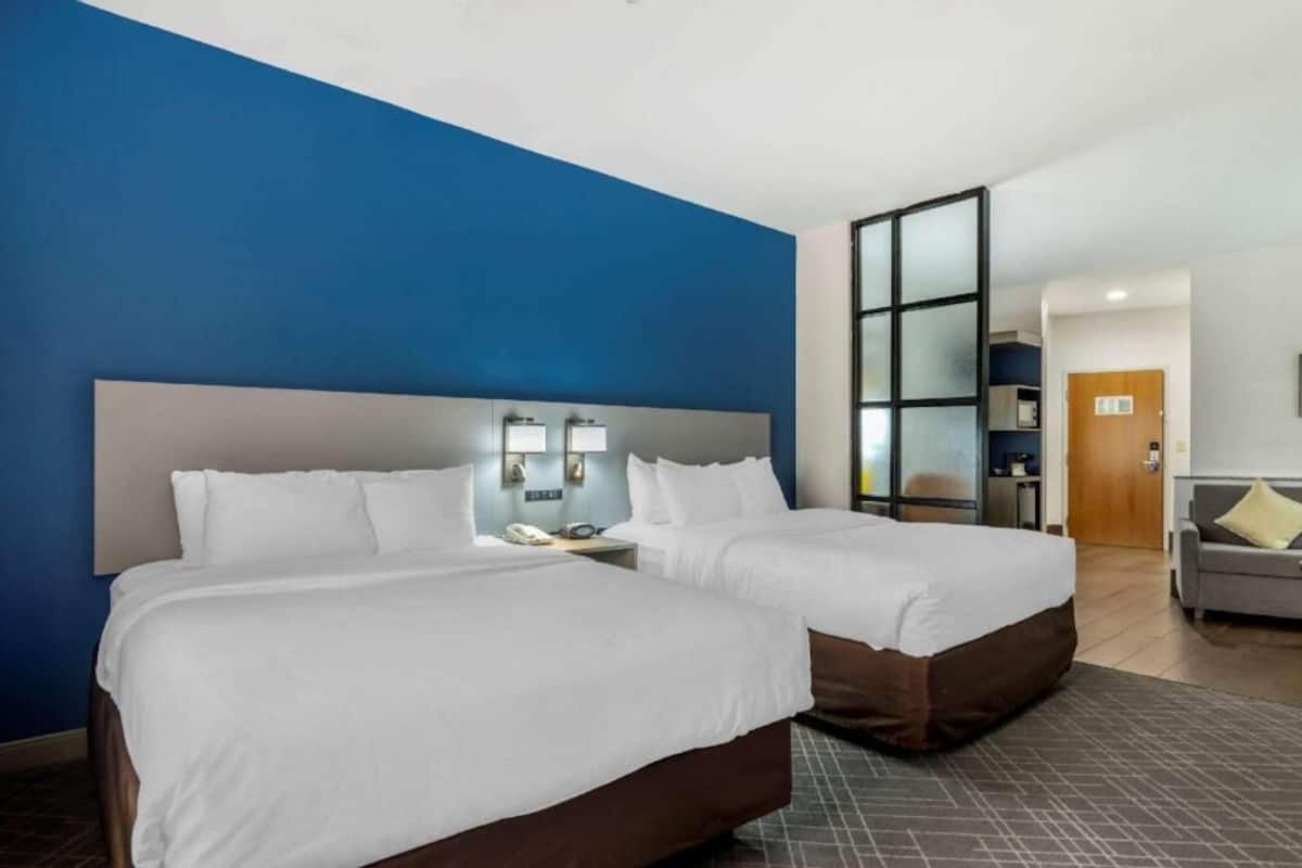 Ein Hotelzimmer mit zwei Betten, einem großen Fenster und einer separaten Sitzecke.