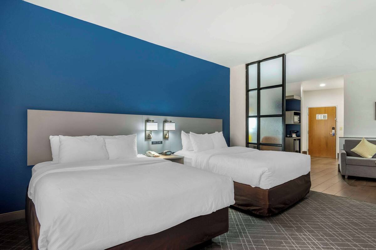 Ein Hotelzimmer mit zwei Betten, einem großen Fenster und einer separaten Sitzecke.