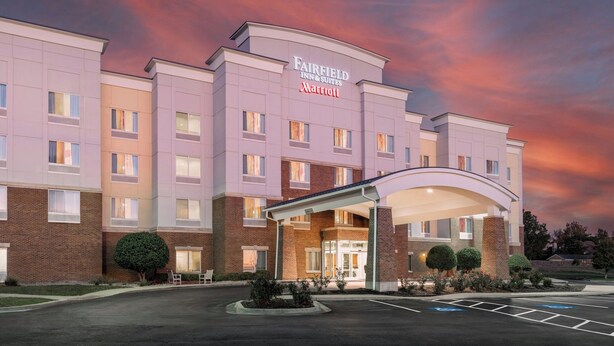 Un hotel Fairfield Inn & Suites Marriott con fachada de ladrillo, entrada cubierta y estacionamiento.