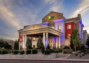 A Holiday Inn Express hotel with a central entrance, columns, and a landscaped front yard.
