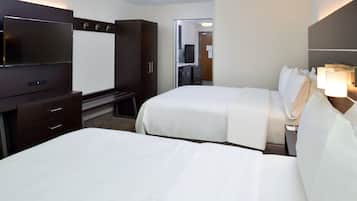 Quarto de hotel com duas camas, televisão, escrivaninha e guarda-roupa.
