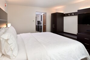 A hotel room with a large bed, a wardrobe, a television, and a mirror. - Holiday Inn Express & Suites Pueblo North by IHG (Pueblo)