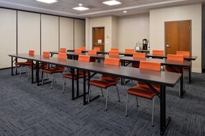 Une salle de conférence équipée d’une longue table, de nombreuses chaises et d’un coin café.