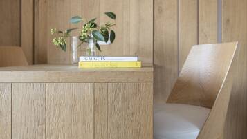 A wooden table with two books and a small vase with flowers.