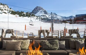 A cozy seating area with a fire feature, overlooking a ski slope and a mountain. - Grau Roig Andorra Boutique Hotel & Spa (Grau Roig)