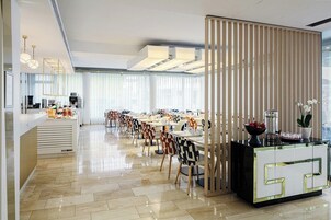 Uma sala de jantar moderna com uma mesa comprida, cadeiras e um balcão com design decorativo.