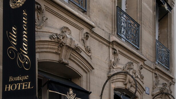 A boutique hotel with ornate architectural details, including a balcony with balustrades and wrought iron railings. - Hôtel Villa Glamour (Paris)