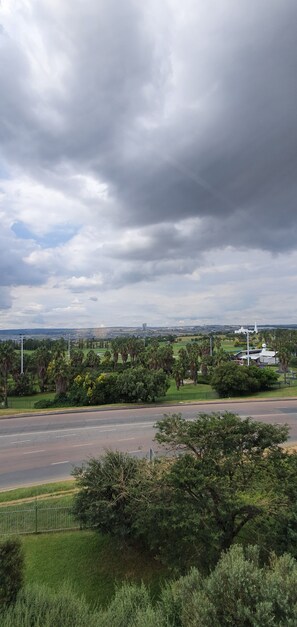A road with a grassy area and trees on the side. - Holiday Inn Express Sandton Woodmead by IHG (Sandton)