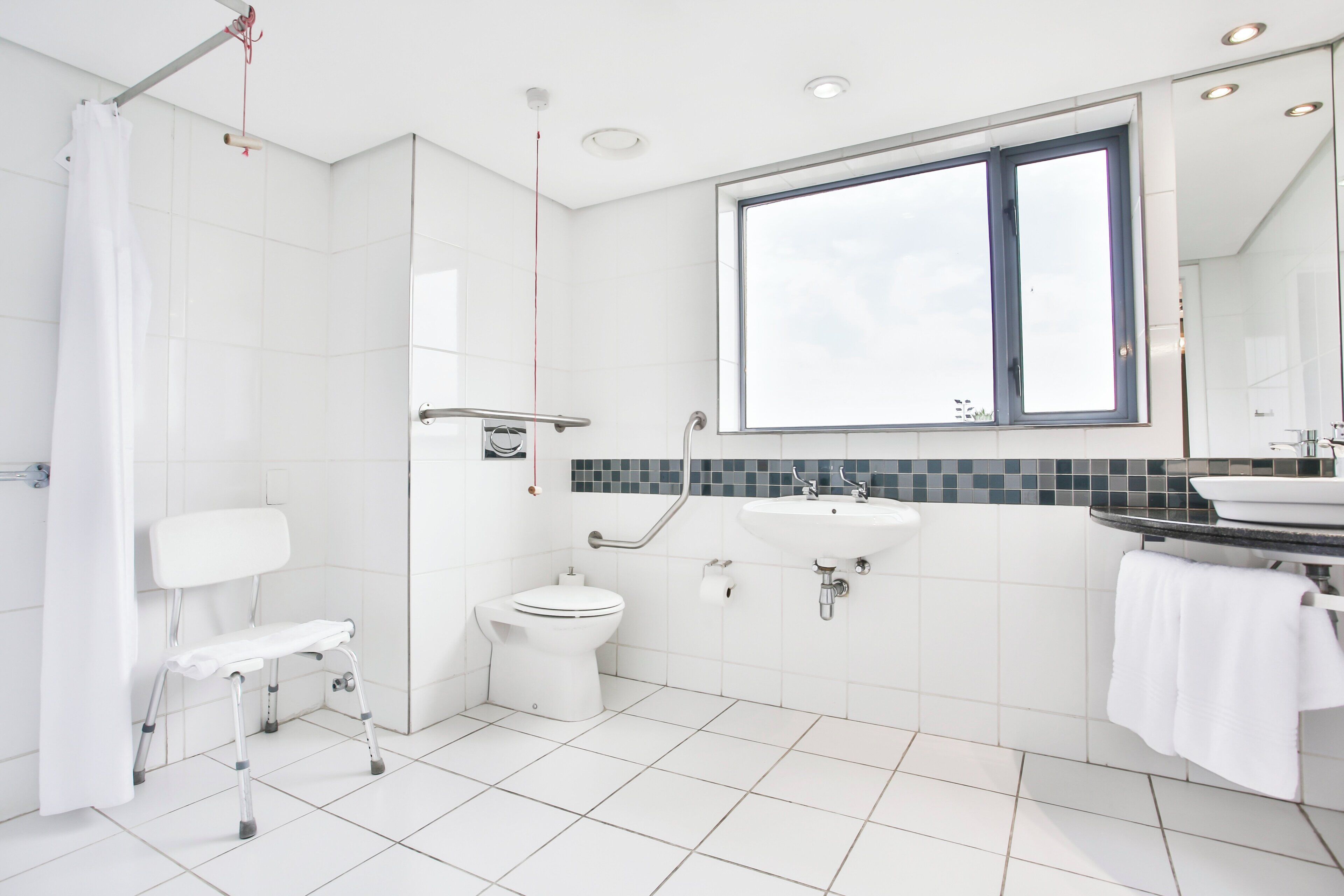 A modern bathroom with a shower, toilet, and sink.