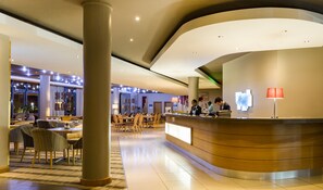 A modern hotel lobby with a reception desk, seating area, and a large column. - Holiday Inn Express Sandton Woodmead by IHG (Sandton)