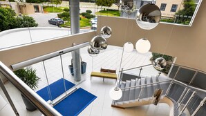 A modern indoor space with a staircase, metal railings, and hanging spherical light fixtures. - Holiday Inn Express Sandton Woodmead by IHG (Sandton)