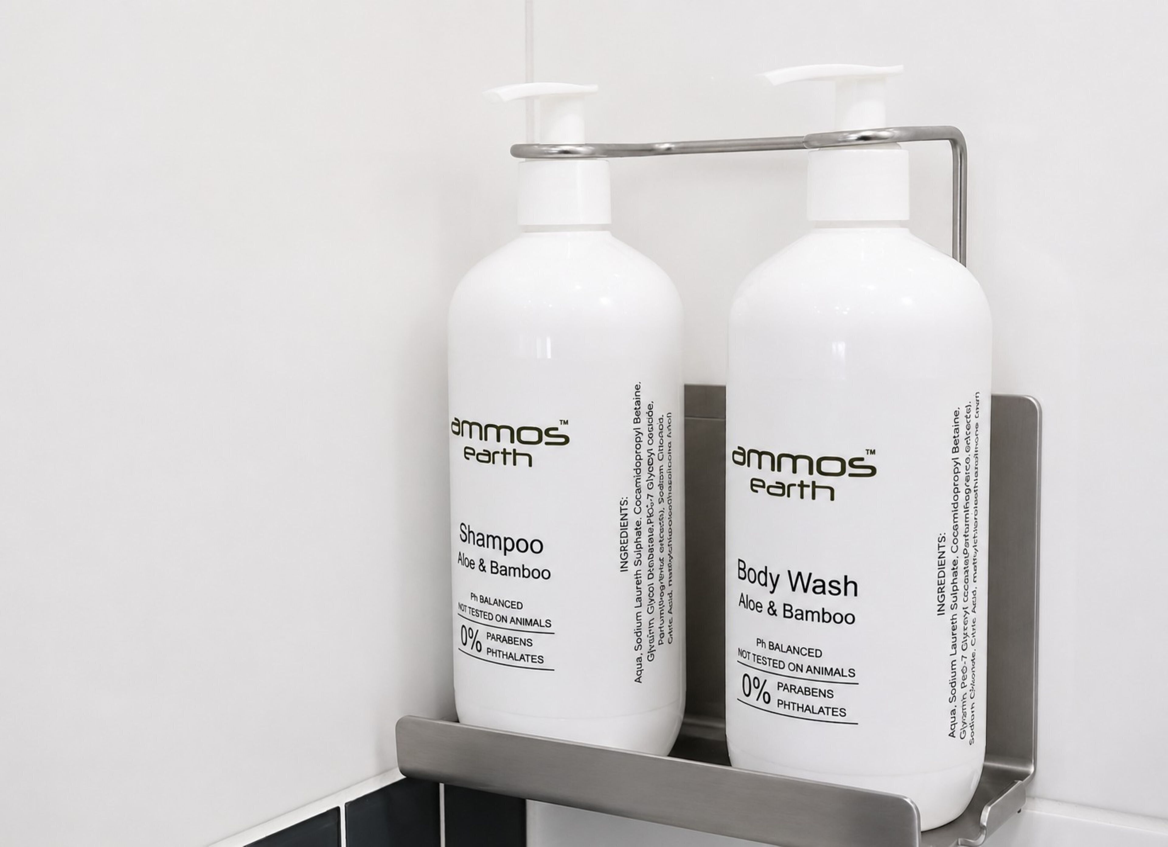Two bottles of Ammos Earth shampoo and body wash on a metal shelf.