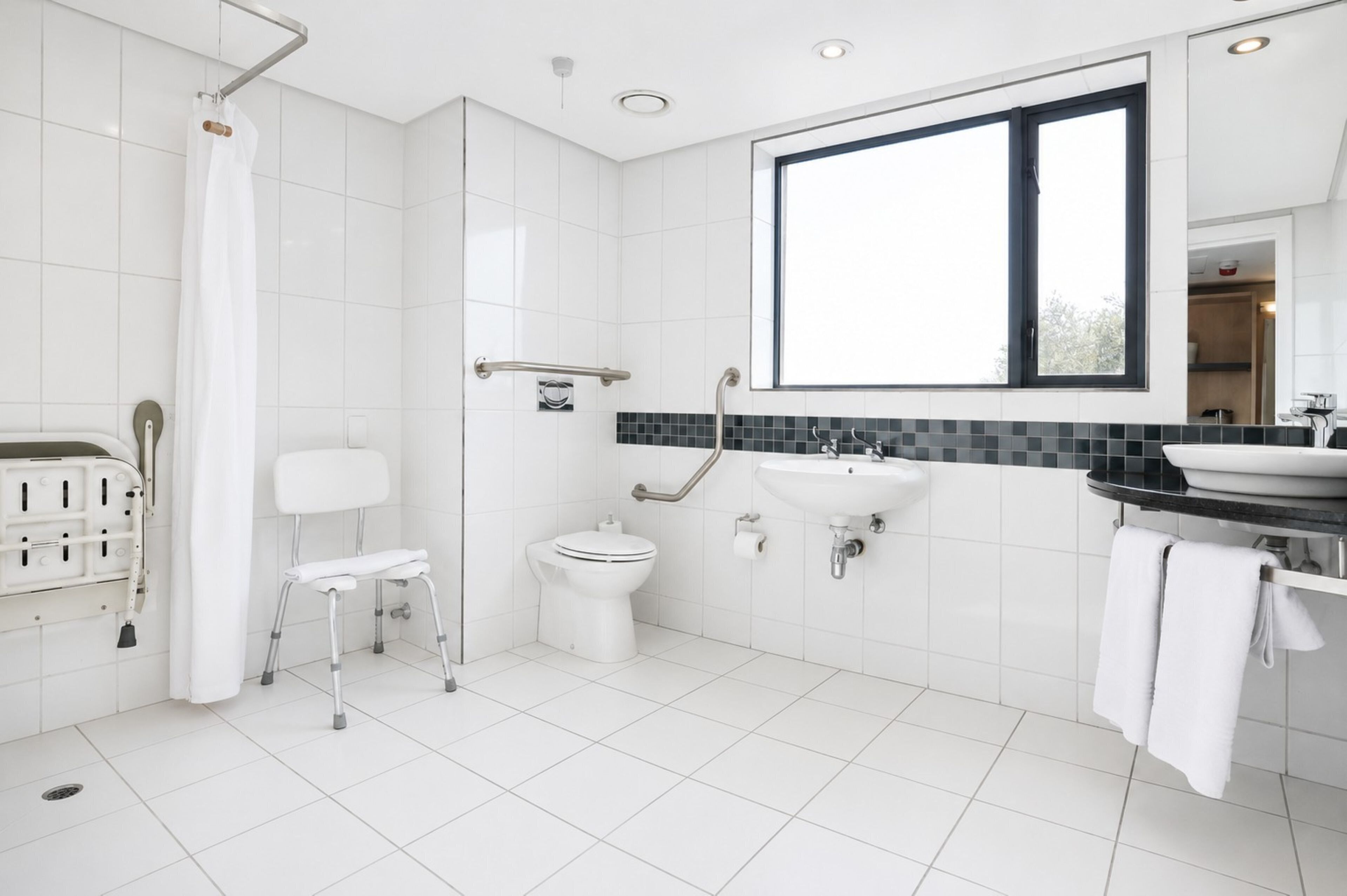 A modern bathroom with a shower, toilet, and sink.