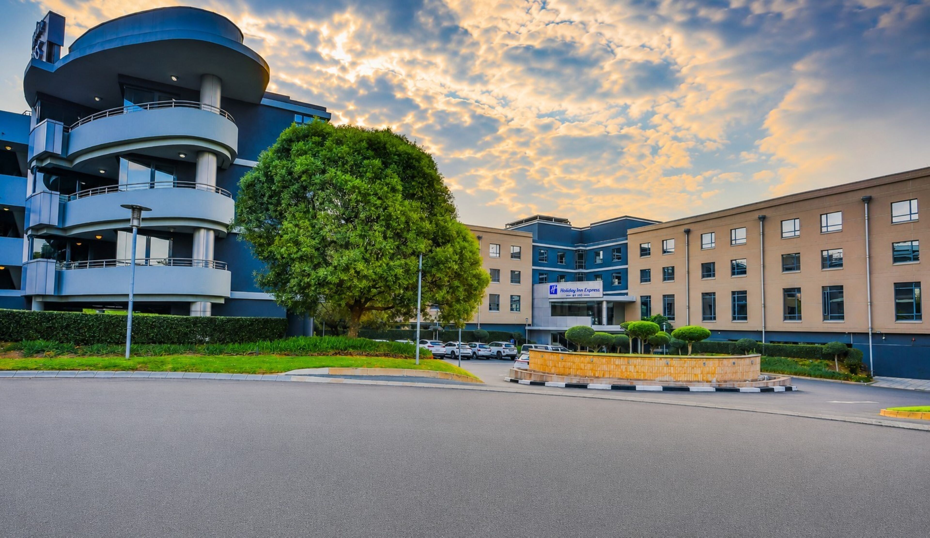 A hotel with a modern design, featuring a circular building and a flat-roofed structure.