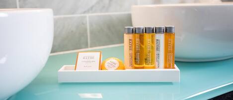 A bathroom with a white sink, a blue countertop, and a shelf with bath products including a cleansing bar and shampoo.