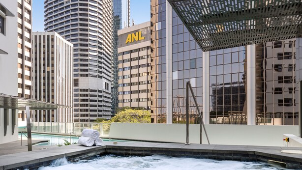 Un jacuzzi con vistas a edificios altos, incluyendo uno con el logotipo 'ANL'.