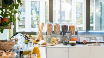 A breakfast buffet with various food items and beverages, including bread, cereal, and juice.