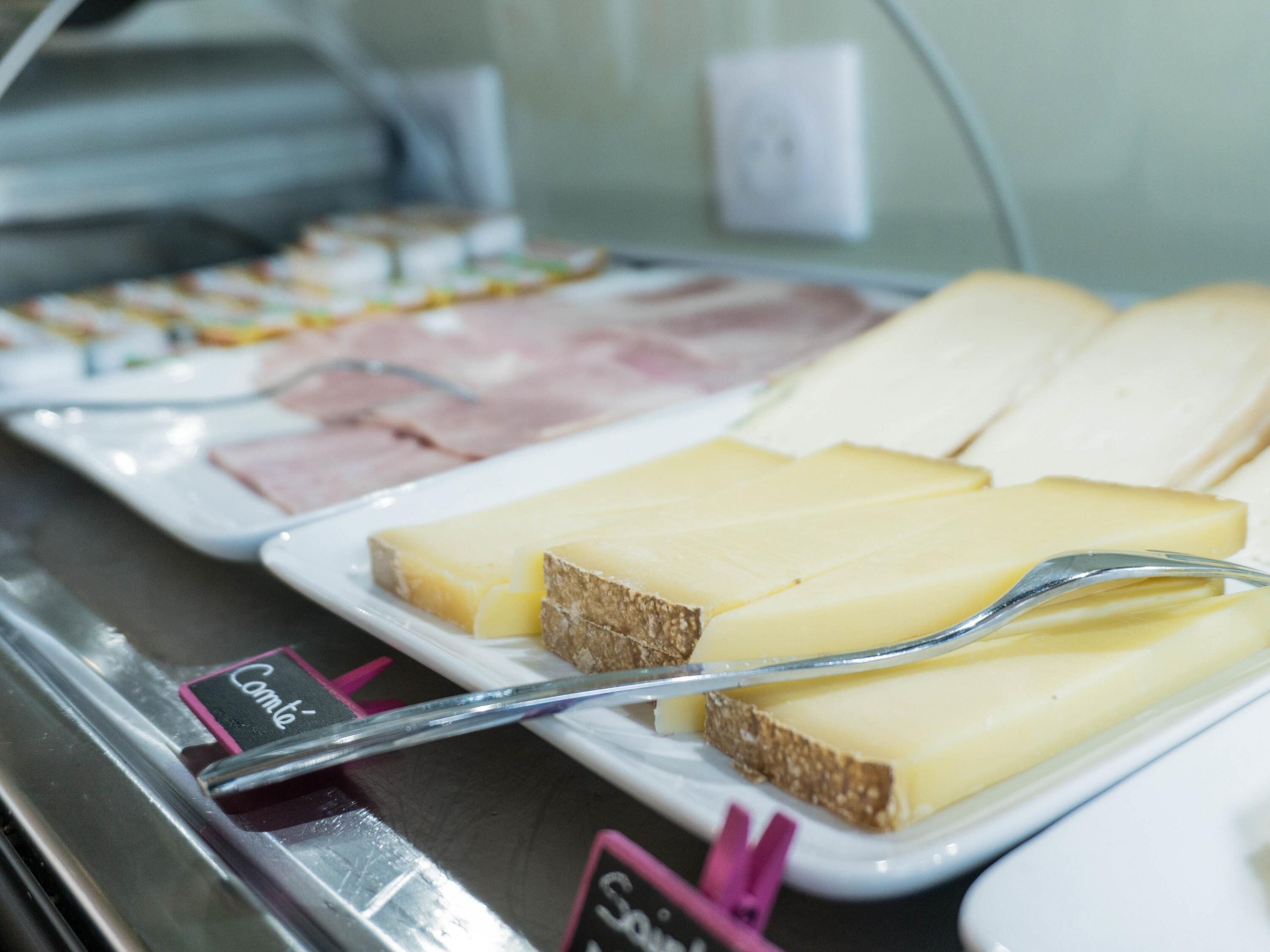 A buffet with various food items including cheese, ham, and bread.