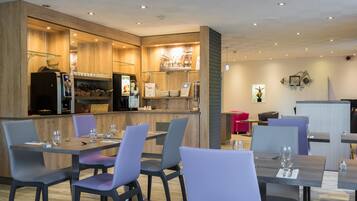 A modern restaurant with a wooden interior, bar area, and seating for diners.