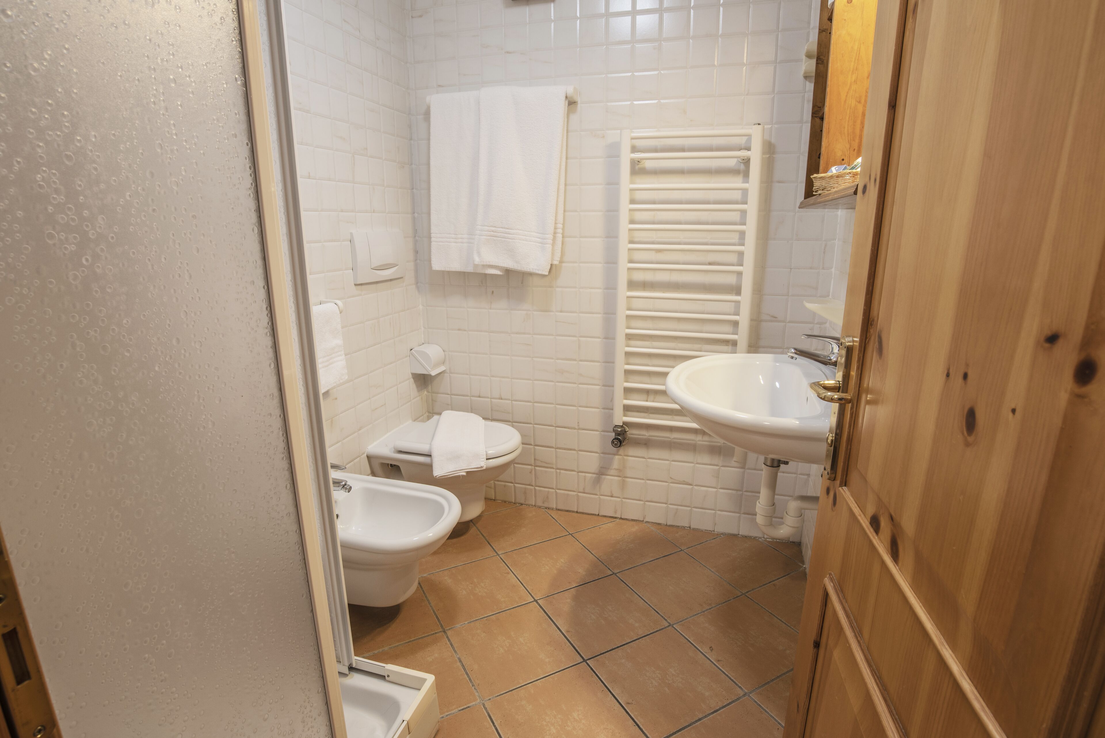 A bathroom with a toilet, bidet, and sink.