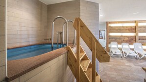 A swimming pool with a wooden staircase leading up to it, surrounded by lounge chairs and a wooden wall. - Sporting Clubresidence (Primiero San Martino di Castrozza)