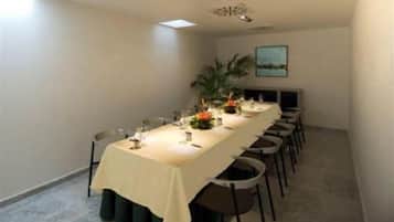 Una sala de conferències amb una taula llarga, cadires i una petita planta sobre la taula.