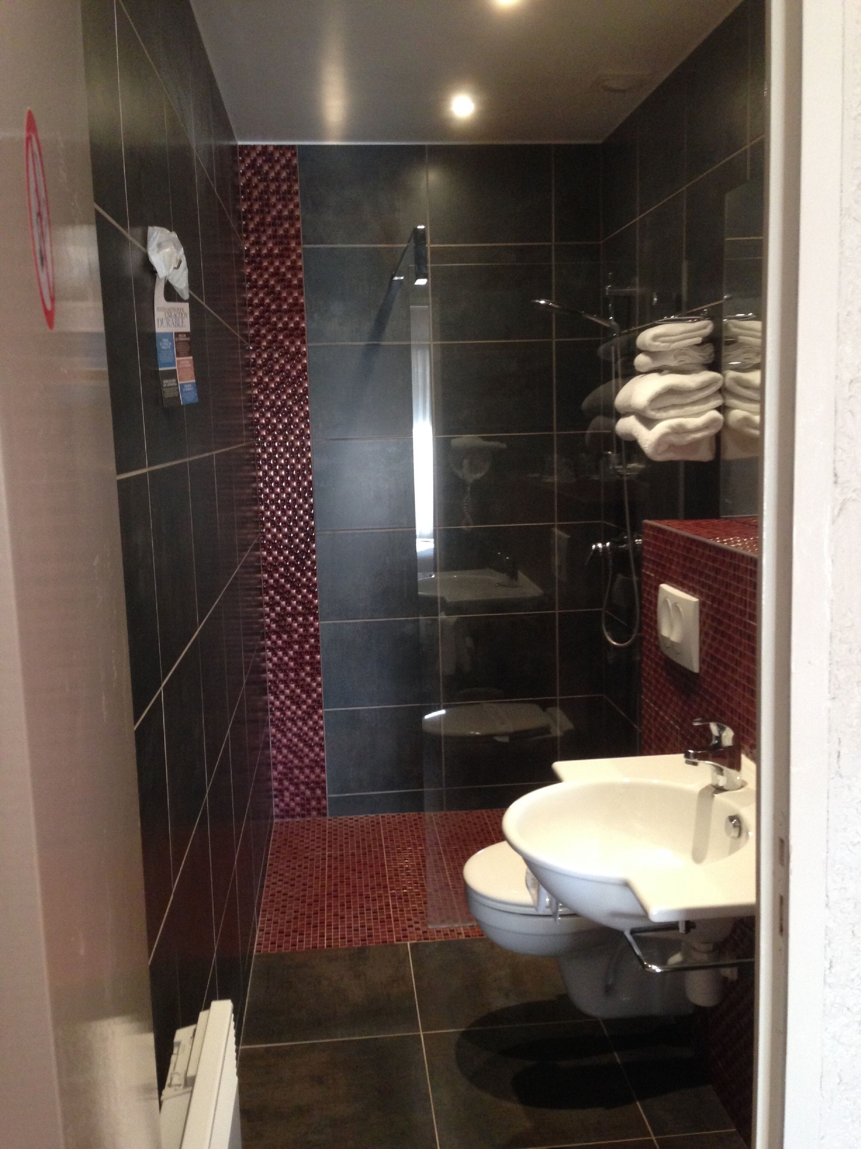 Een moderne badkamer met douche, toilet en wastafel.