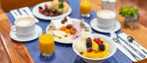 A breakfast setting with a variety of dishes including pancakes, fruit, and a coffee cup.