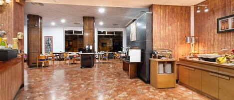 A spacious cafe with wooden paneling, a polished tile floor, and a variety of seating options including tables and chairs.