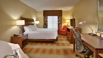 Une chambre d’hôtel équipée d’un lit, d’un bureau, d’une chaise, d’une télévision et d’une salle de bain avec un lavabo et un miroir.