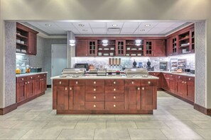 A spacious kitchen with a central island, wooden cabinets, and a microwave.