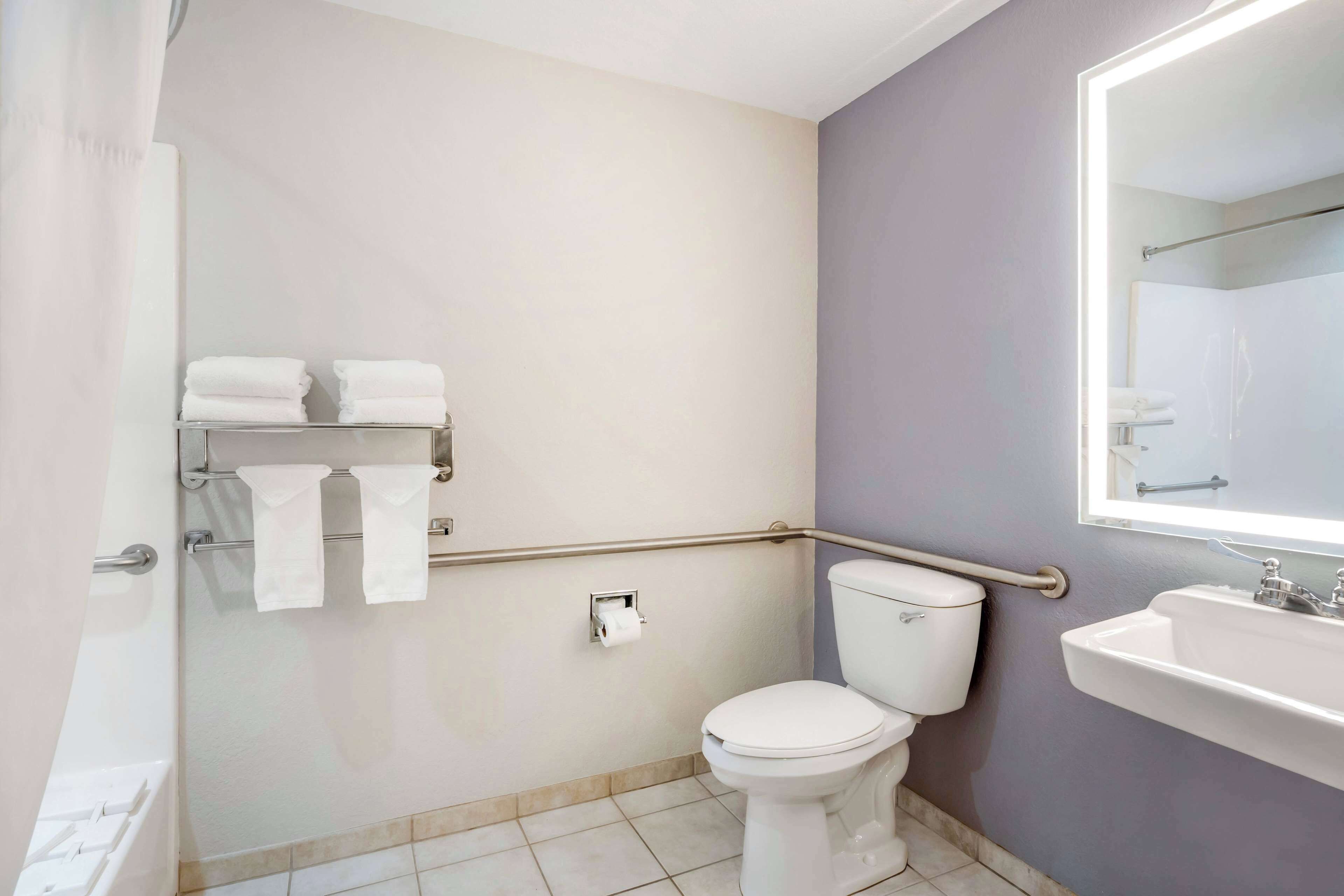 A bathroom with a toilet, sink, and towel rack.