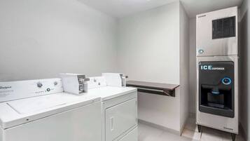 A laundry area with a Whirlpool washer, a dryer, and an ICE dispenser.