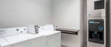 A laundry area with a Whirlpool washer, a dryer, and an ICE dispenser.