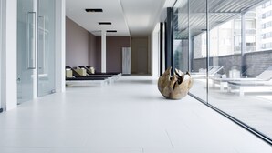 Un vestíbulo moderno y amplio con diseño minimalista, que incluye un mostrador de recepción, una zona de estar y grandes ventanales con vistas a la ciudad.