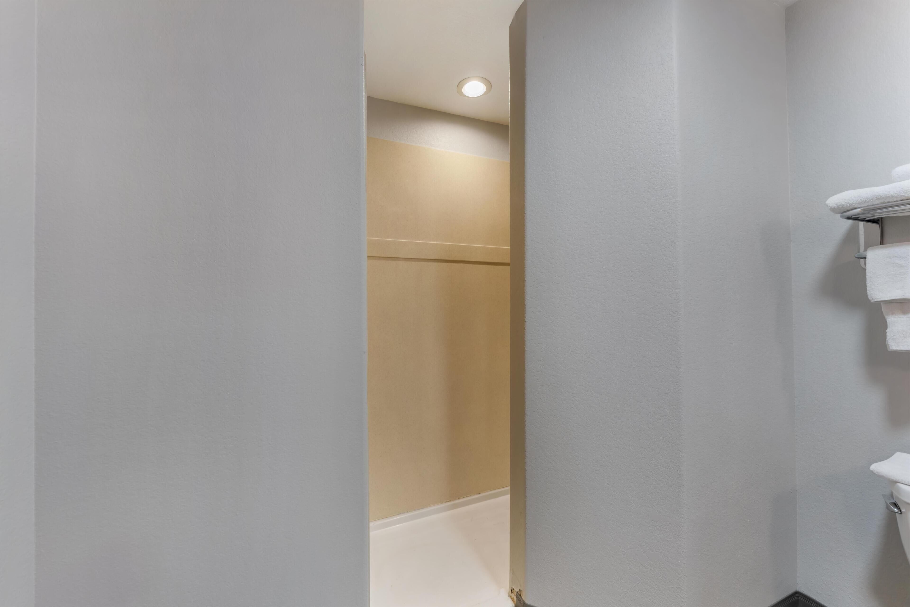 A bathroom with a white sink, a towel rack, and a shower area.