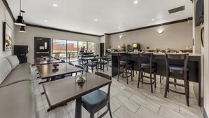 Un restaurante moderno con barra, distribución de mesas y vistas al exterior.