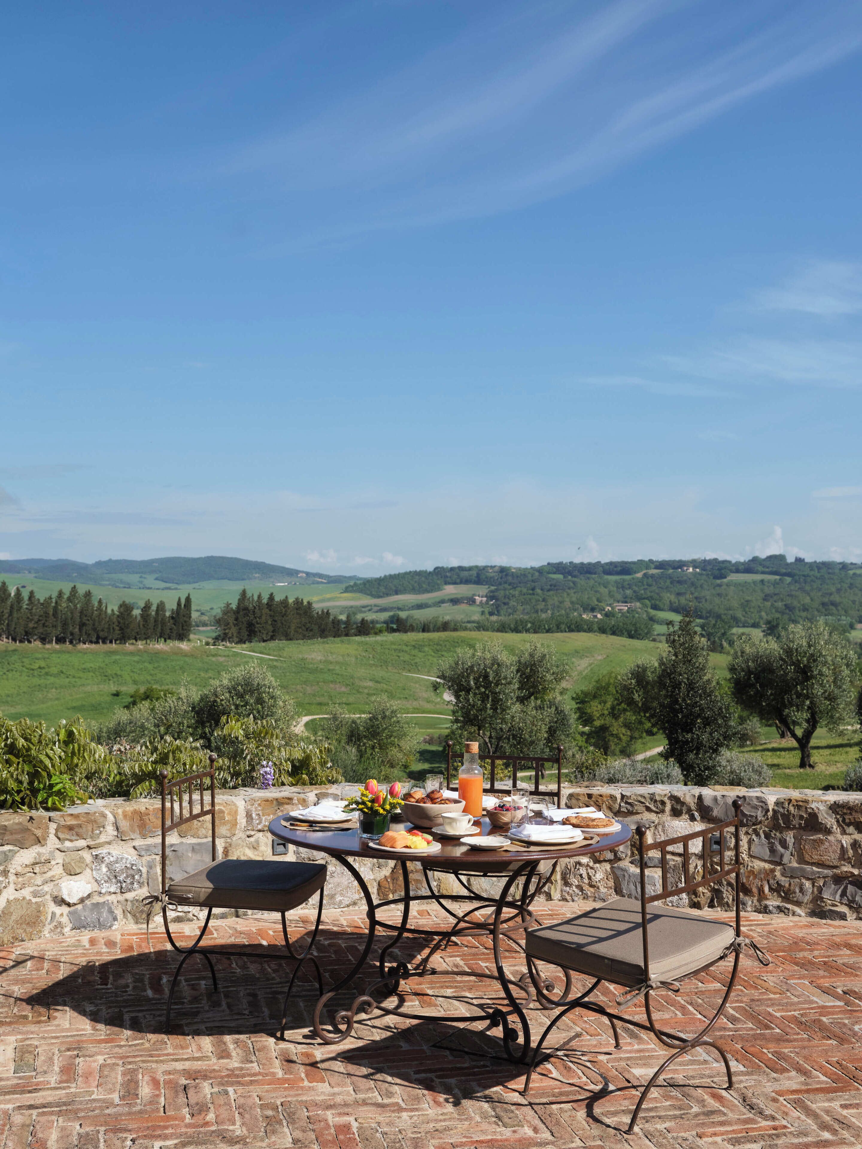 Une table en pierre offrant une vue sur des collines ondoyantes et un ciel dégagé.