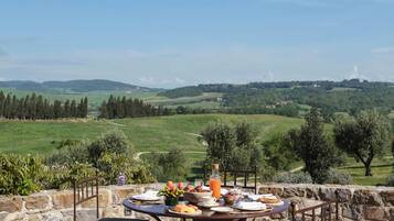 Une table en pierre offrant une vue sur des collines ondoyantes et un ciel dégagé.