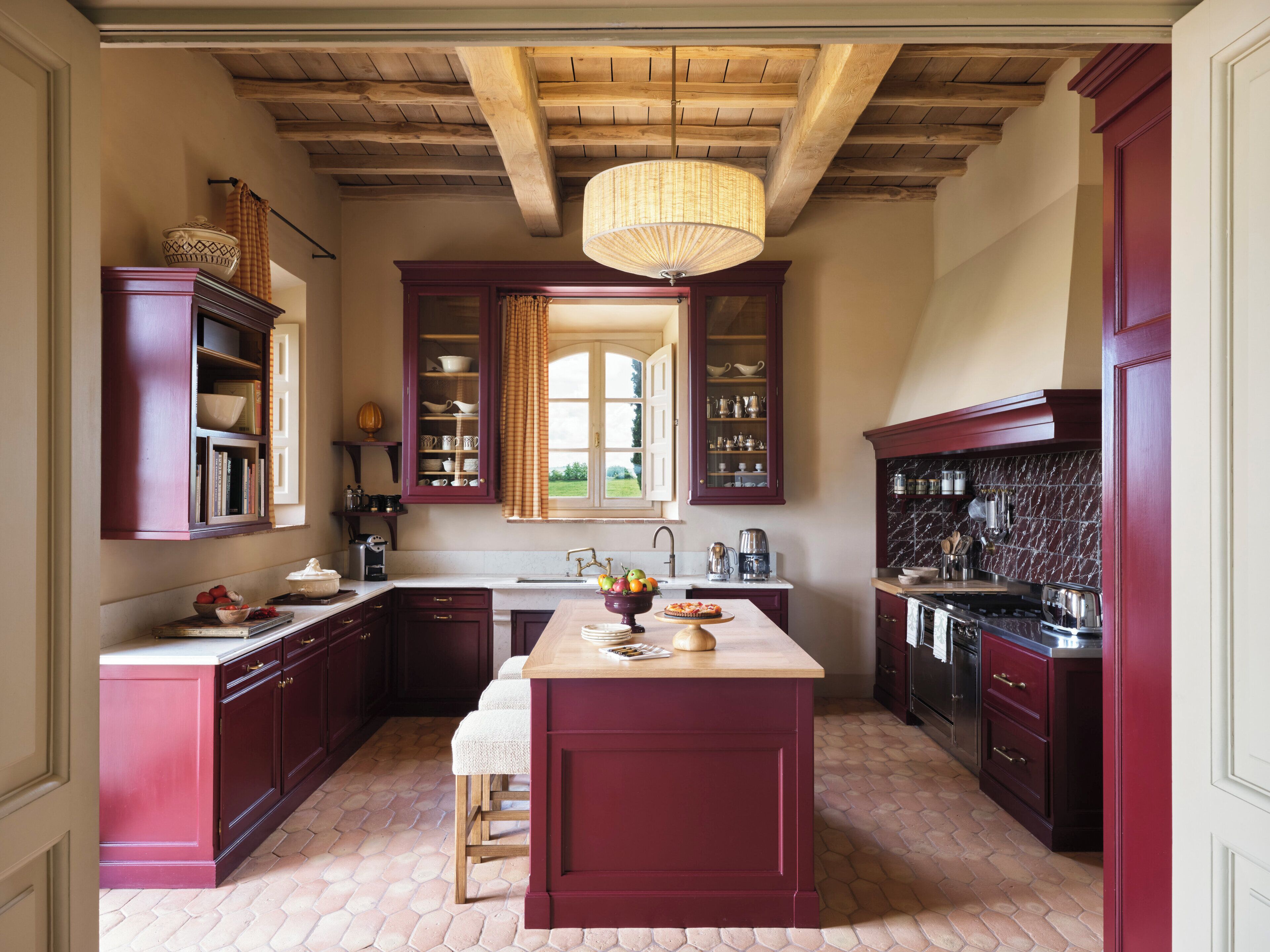 A kitchen with dark wooden cabinets, a central island, and a hanging light fixture.