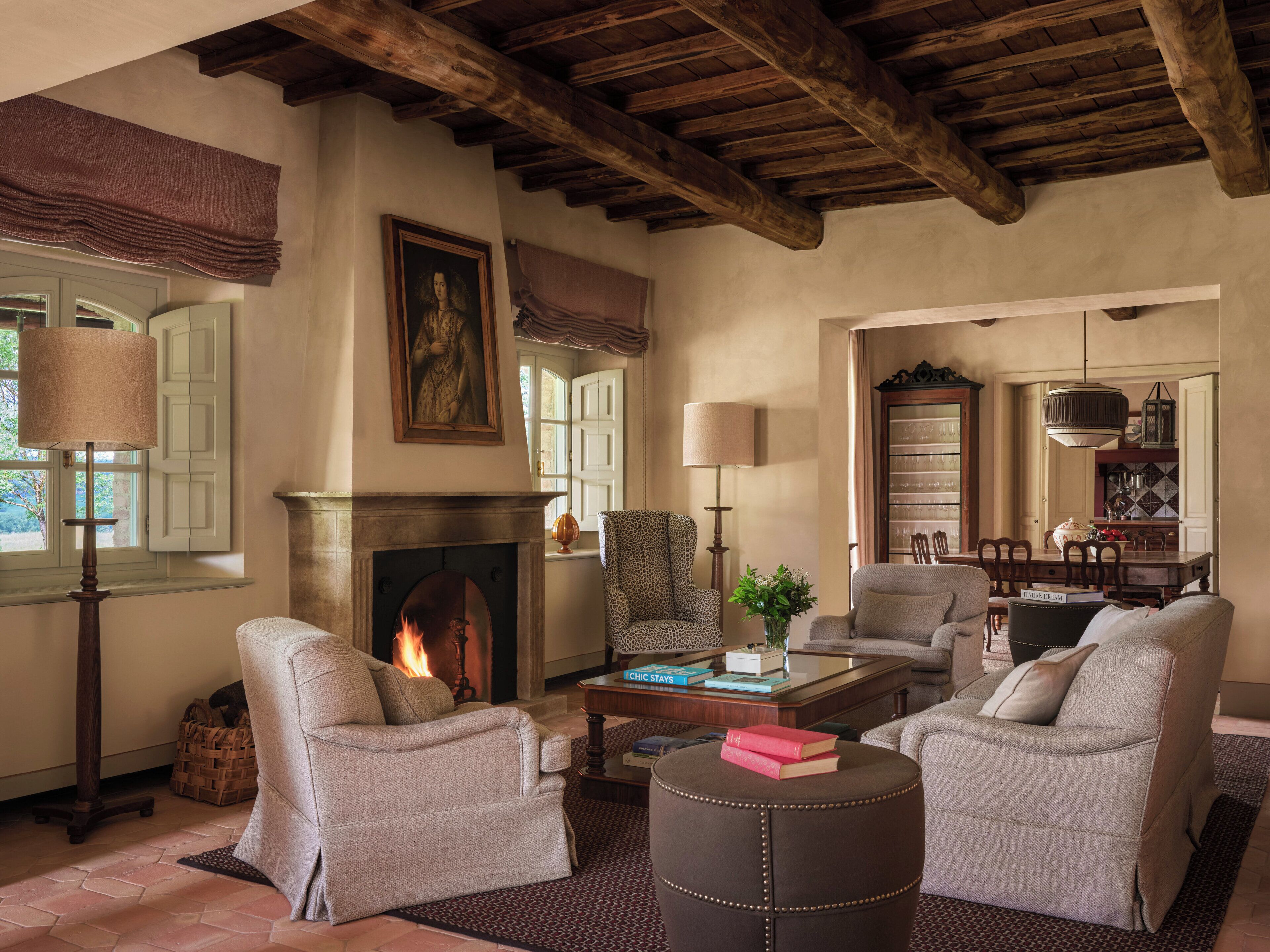 A cozy living room with a fireplace, comfortable seating, and a dining area.
