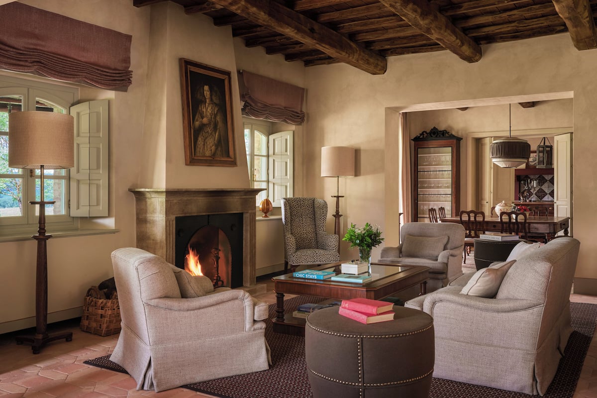 Una sala de estar acogedora con chimenea, asientos cómodos y un comedor.